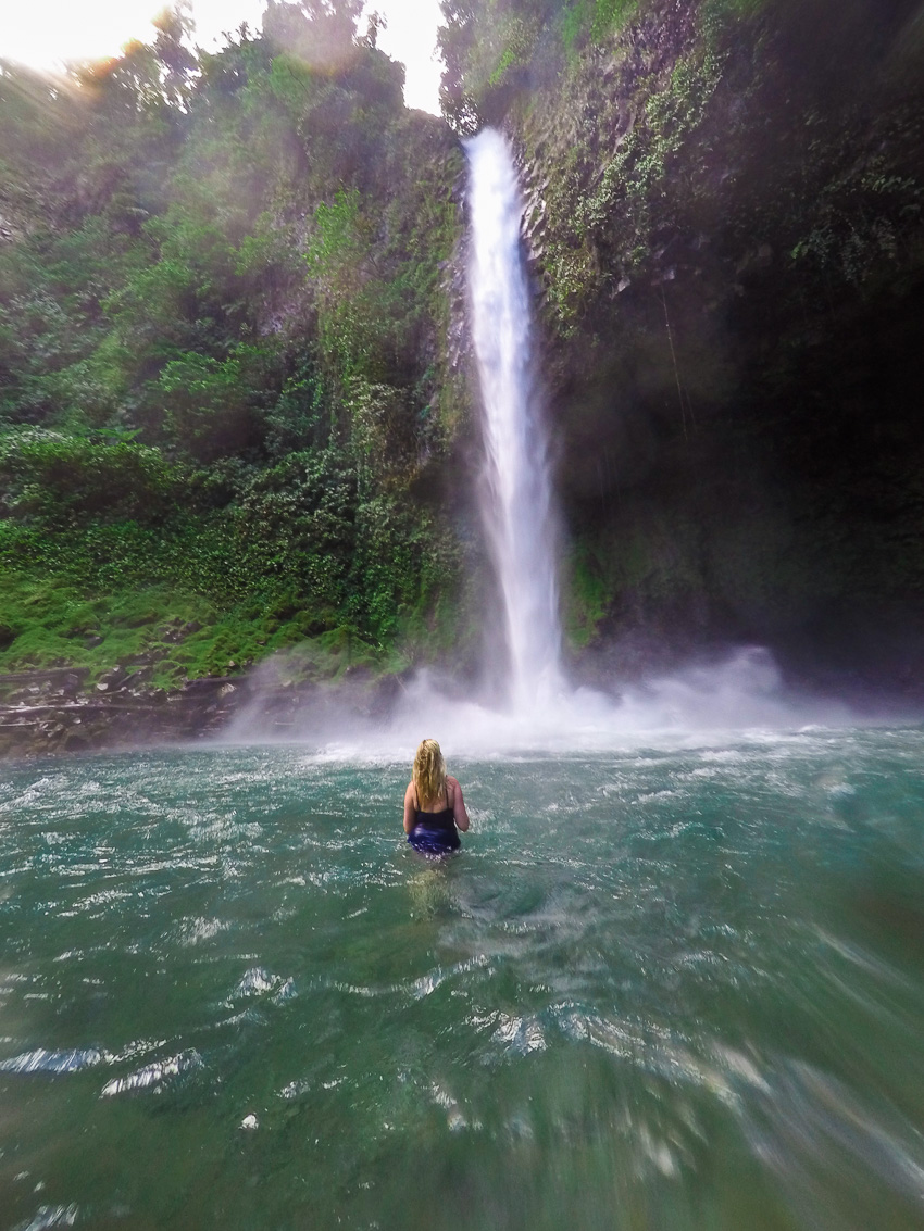 Madison in water at the bottom of La Fortuna Waterfall